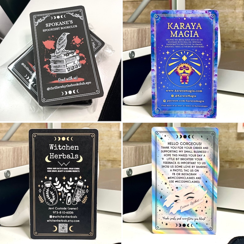 May include: Four business cards with different designs. The first card is black with a red and white illustration of a raven reading a book. The text on the card reads "Spokane's Spookiest Bookclub". The second card is blue with a purple, pink, and gold illustration of a creature with a star on its head. The text on the card reads "Karaya Magia". The third card is black with a white illustration of three bottles with herbs. The text on the card reads "Witchen Herbals". The fourth card is iridescent with a rainbow design and the text "Hello Gorgeous! Thank you for your order and supporting my small business! I hope this makes your day a little bit brighter! Your feedback is important to us! Show us some love by sharing a photo, tag us on FB or Instagram, use #cosmiclashes and #cosmiclashes".