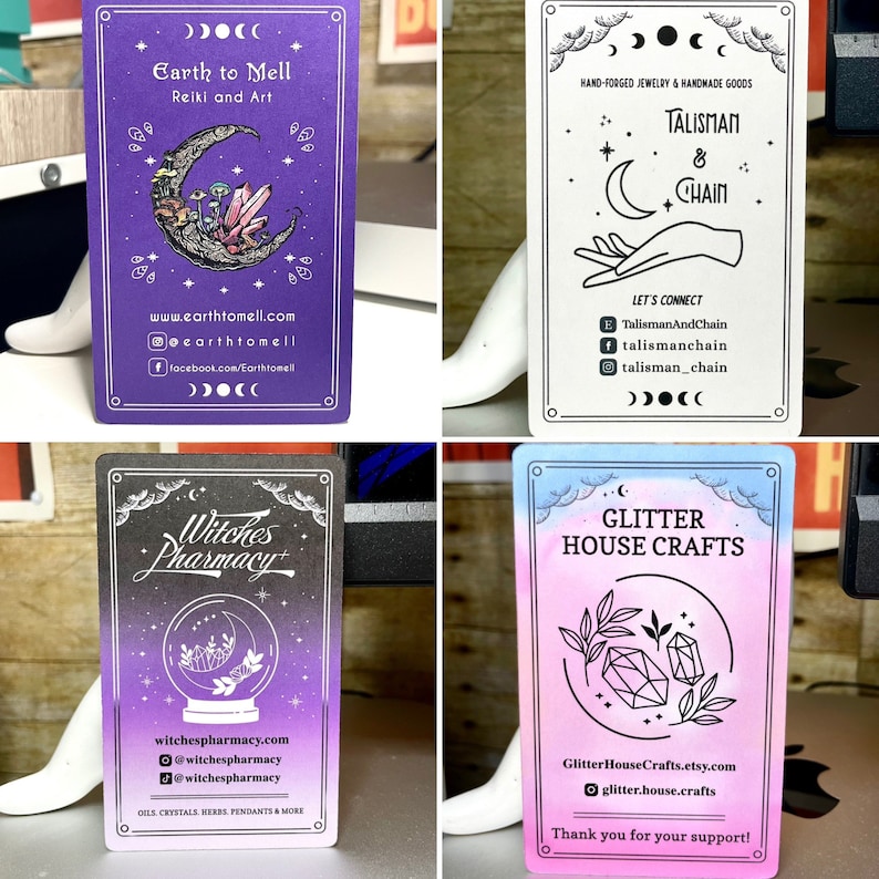 May include: Four business cards with a purple, black, pink, and blue gradient background. The cards feature illustrations of a crescent moon, crystals, a witch's cauldron, and a crystal. The text on the cards reads "Earth to Mell Reiki and Art", "Talisman & Chain", "Witches Pharmacy", and "Glitter House Crafts".