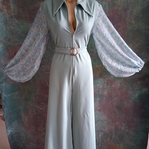 A stunnning sage green 1970s style flared zip up jumpsuit with pure silk floral chiffon balloon sleeves.