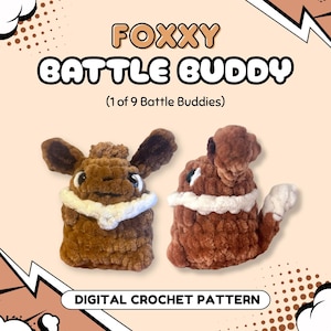 Könnte beinhalten: Eine digitale Häkelanleitung mit dem Titel FOXXY BATTLE BUDDY (1 of 9 Battle Buddies) von nerdypeachstitches. Das Bild zeigt zwei braune Plüschkreaturen mit weißen Halskrausen, dunklen Augen und spitzen Ohren als fertiges Design.