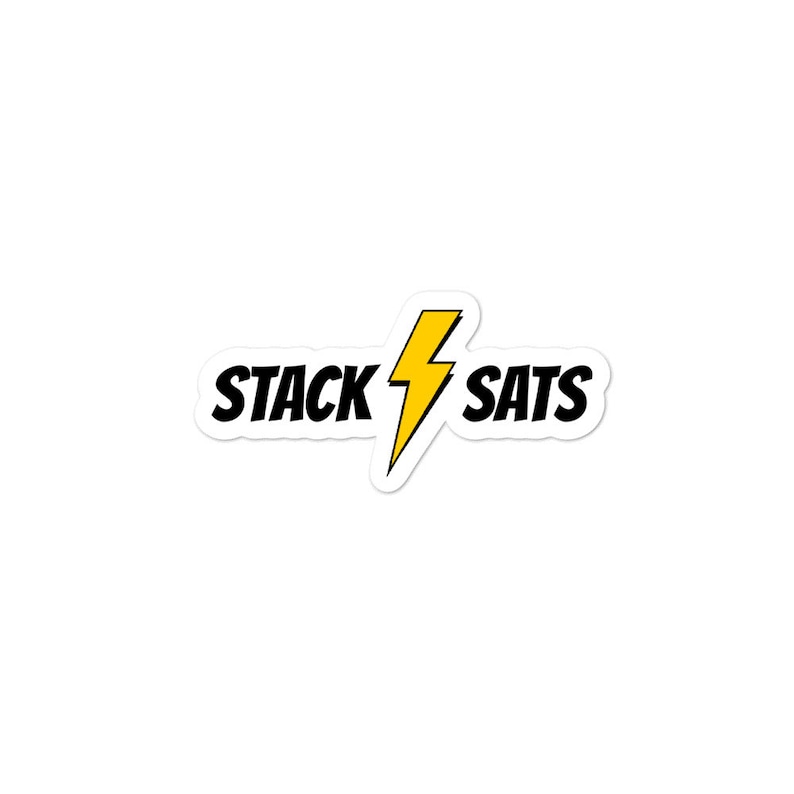Pu&ograve; includere: Un adesivo bianco con la scritta "STACK SATS" in nero, con un fulmine giallo al centro. L'adesivo ha un bordo nero.