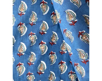 May include: Blue fabric with a repeating pattern of white, green, and brown paisley leaves. The leaves have a red stem.