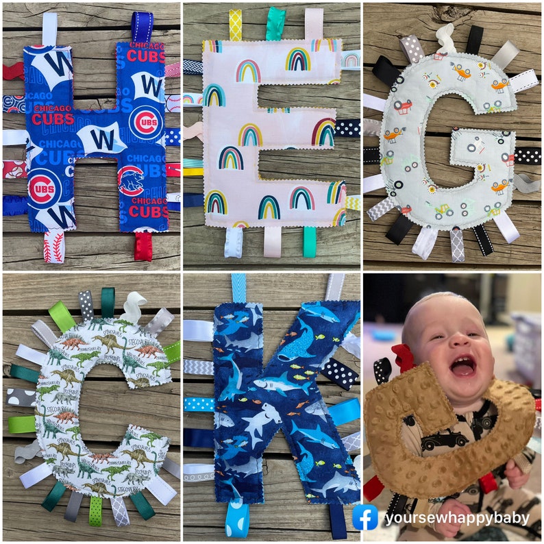 May include: A set of six colorful fabric baby toys in the shape of the letters H, E, G, C, K, and a brown toy with a red ribbon. The letters are made of different fabrics with various patterns, including rainbows, dinosaurs, and sharks. The toys are designed for babies to explore and learn.
