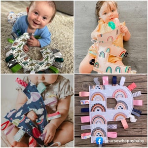 May include: A set of three colorful fabric baby toys shaped like letters. Each letter is decorated with a rainbow pattern and has multiple ribbons attached. The toys are perfect for stimulating a baby's senses and promoting fine motor skills.
