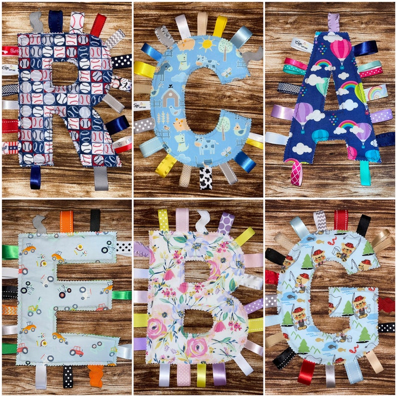 May include: A set of six baby sensory blankets, each featuring a different letter of the alphabet. The blankets are made of soft fabric and have a variety of textures and colors. Each blanket has a different pattern, including baseballs, flowers, and farm animals. The blankets are perfect for babies to explore and learn.