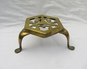 Antique brass trivet with pierced top and characterful cabriole legs.