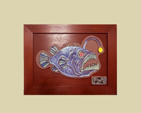 A geometric, mid-century modern anglerfish rendered as a ceramic sculpture — looks like it escaped a gallery in the best possible way.