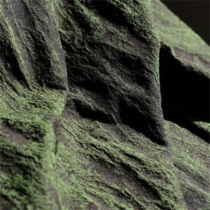 May include: Close-up of textured fabric with a dark green and black color scheme. The fabric has a rough, uneven surface with a pattern of ridges and valleys, creating a sense of depth and texture. The lighting highlights the fabric's details.