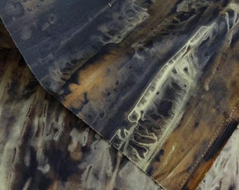 May include: A piece of fabric featuring a dark, moody tie-dye pattern with deep charcoal, black, and muted brown tones. The design displays organic, flowing shapes and blurred, streaky lines that create a textured, layered appearance across the surface.