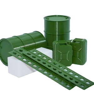 Puede incluir: Colección de modelos en miniatura verdes, incluyendo barriles, bidones y tiras de metal perforadas. Los objetos están dispuestos sobre una superficie blanca, mostrando un tema militar o industrial. Los modelos son probablemente de plástico.