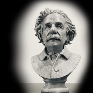 Puede incluir: Un busto gris y moteado impreso en 3D de Albert Einstein con su característico cabello alborotado, un bigote prominente y una chaqueta con cuello. La escultura muestra líneas de capa horizontales visibles del proceso de impresión.