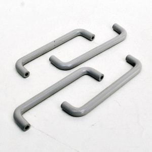 Könnte beinhalten: Vier graue Kunststoff-Schrankgriffe mit abgerundeter Form. Die Griffe sind in verschiedenen Größen.