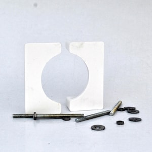 May include: Two white plastic pipe clamps with a round hole in the center, along with several silver screws and washers.