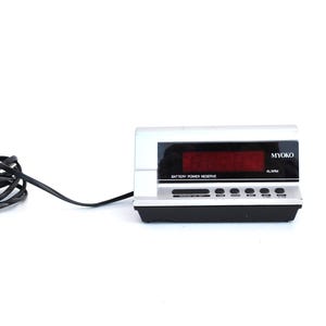 Puede incluir: Una taza de cerámica blanca con un asa negra y el texto "But First, Coffee" en un estilo manuscrito. La taza está sobre una superficie blanca. La taza mide aproximadamente 10 cm de alto.