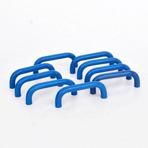 Può includere: Otto maniglie blu in metallo disposte su una superficie bianca. Ogni maniglia ha una parte superiore curva e due gambe curve verso il basso. Le maniglie sono distanziate uniformemente.