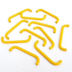 Könnte beinhalten: Eine Ansammlung leuchtend gelber, gebogener Metallgriffe auf weißem Hintergrund. Die Griffe haben ein abgerundetes, röhrenförmiges Design mit offenen Enden, was auf einen bestimmten Zweck oder eine Anwendung hindeutet.