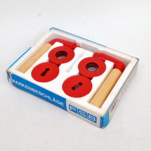 May include: A white ceramic mug with a black handle and the text "But First, Coffee" in a black, handwritten-style font. The mug is on a white surface.