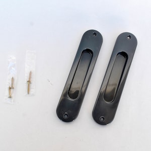 Puede incluir: Dos tiradores de puerta rectangulares negros con bordes redondeados y un tirador empotrado. Los tiradores se incluyen con dos pequeños paquetes de tornillos.