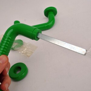May include: A bright green, vintage-style door handle with a metal rod and a matching green circular base. The handle has a curved design with a textured grip. Additional hardware is visible.