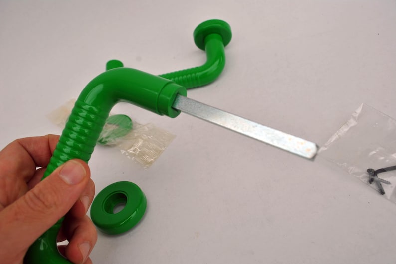 May include: A bright green, vintage-style door handle with a metal rod and a matching green circular base. The handle has a curved design with a textured grip. Additional hardware is visible.