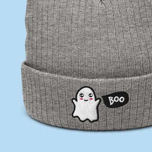 以下が含まれることがあります： グレーのニットビーニー。前面に白い幽霊と黒い吹き出しが刺繍されており、吹き出しには「BOO」と書いてあります。