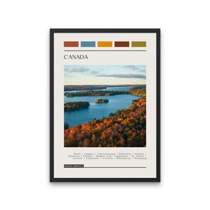 May include: A poster with a scenic image of a lake surrounded by fall foliage in Canada. The poster features the text "CANADA" and a list of Canadian cities. The poster is framed in black.