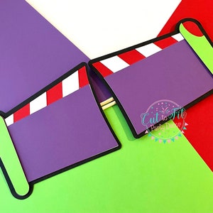 May include: Two purple and green photo booth props shaped like a finger pointing. Each prop has a red and white striped design and a blank space for text.