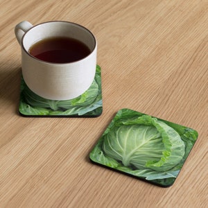 May include: Two square coasters with a green cabbage design. The coasters are made of a hard material and have a black border.