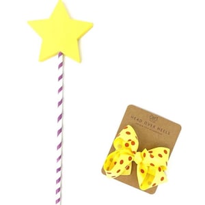 May include: A yellow star-shaped wand with a purple and white striped stick. A yellow bow with red polka dots is on a brown card with the text "Head Over Heels Boutique Hair Accessories".