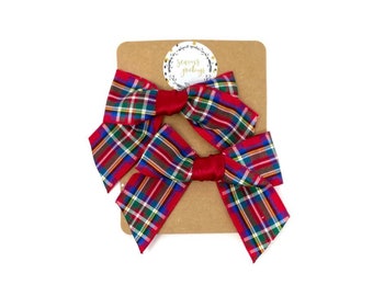 May include: Two red and green plaid hair bows with a brown card that says "Seasons Greetings".
