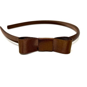 May include: A brown satin headband with a brown satin bow.