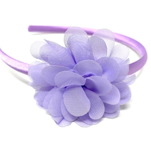 May include: A purple headband with a large lavender flower accent.