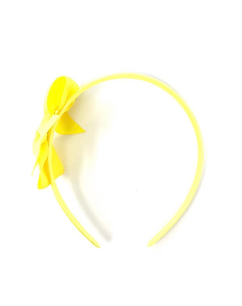 May include: A yellow headband with a yellow bow on the side.