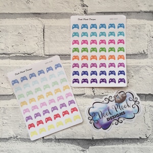 May include: Two sheets of colourful gamer controller stickers. The stickers are in various colours, including blue, green, orange, purple, red, and yellow. The stickers are arranged in a grid pattern on the sheets. The sheets are labelled "Dook Plook Designs" and have the product codes "DPD-037" and "DPD-038".
