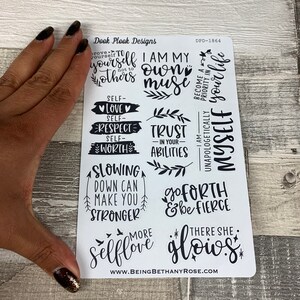 May include: A sheet of white stickers with black lettering and illustrations. The stickers feature positive affirmations such as "I am my own muse", "Trust in your abilities", "Slowing down can make you stronger", "Go forth and be fierce", and "There she glows".