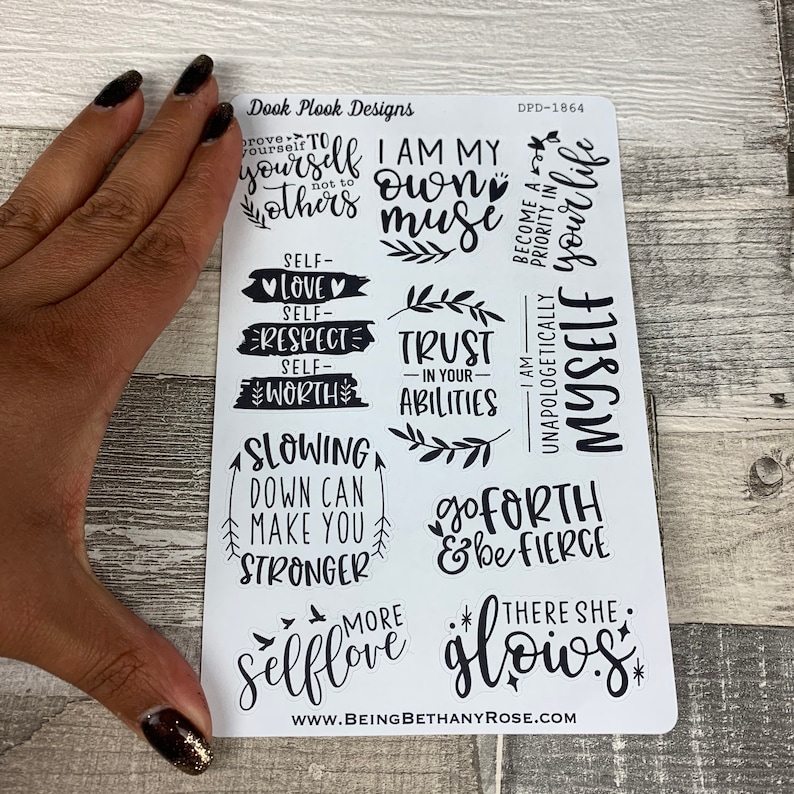 May include: A sheet of white stickers with black lettering and illustrations. The stickers feature positive affirmations such as "I am my own muse", "Trust in your abilities", "Slowing down can make you stronger", "Go forth and be fierce", and "There she glows".