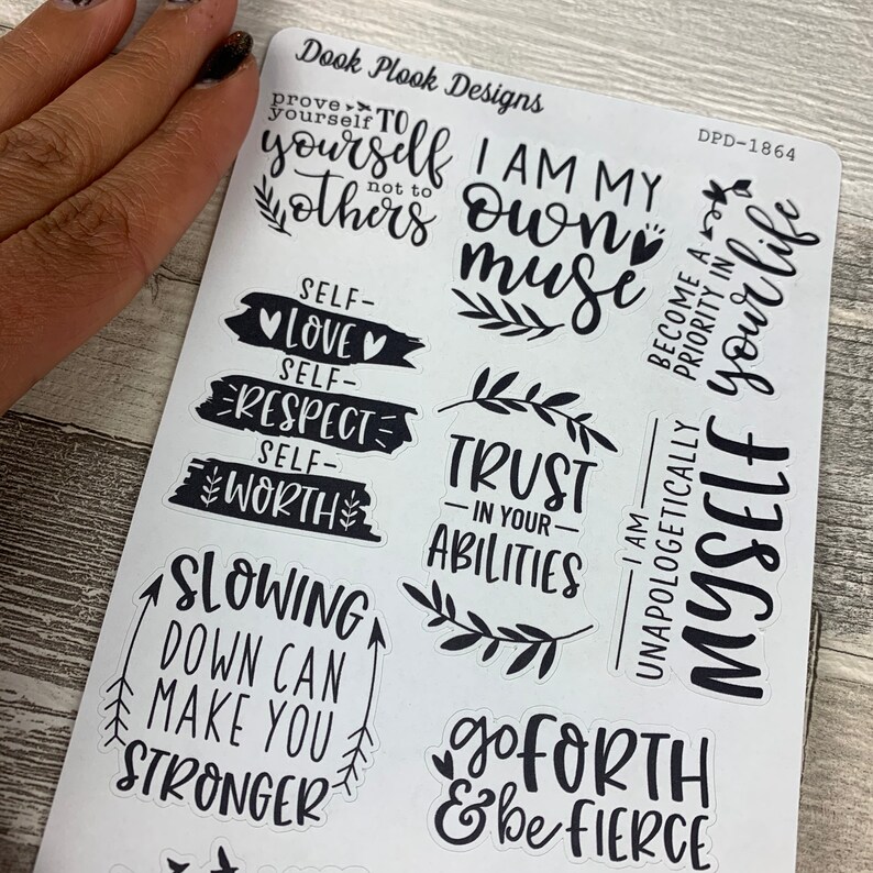 May include: A sheet of black and white stickers with motivational quotes. The quotes include "I am my own muse", "Trust in your abilities", "Slowing down can make you stronger", "Go forth & be fierce", and "Become a priority in your life".