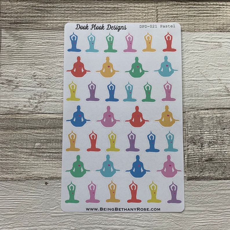 Op de afbeelding: Een vel met pastelkleurige yoga-pose stickers met een roze hart in het midden van elke pose. Het vel is gelabeld "Dook Plook Designs" en "DPD-021 Pastel". De onderkant van het vel zegt "www.beingbethanyrose.com".