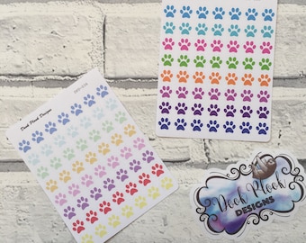 May include: Two sheets of paw print stickers. One sheet has rainbow colored paw prints and the other sheet has blue, green, orange, pink, and purple paw prints. The sheets are labeled "Dook Plook Designs" and have the product codes "DPD-036" and "DPD-035".