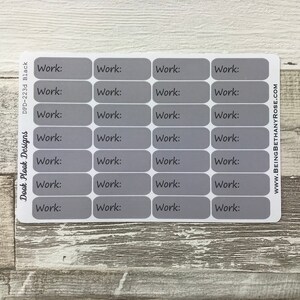 Op de afbeelding: Een vel met 24 grijze rechthoekige stickers met het woord "Work:" erop gedrukt.