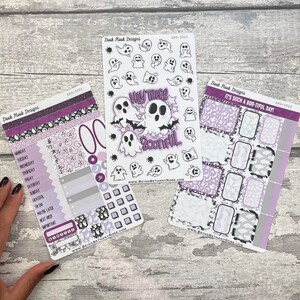 May include: Three sheets of stickers featuring a ghost theme. The first sheet has a variety of ghost illustrations. The second sheet has a larger ghost illustration with the text "Hey There Bootiful". The third sheet has a purple and white pattern with the text "It's Such a Boo-tiful Day!"