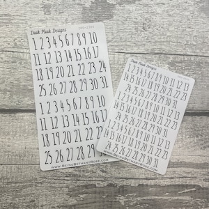 May include: Two sheets of white sticker paper with black numbers 1 through 31 printed on them. The numbers are arranged in rows of ten. The sheets are labelled "Dook Plook Designs" and have the product codes "DPD-2384" and "DPD-0043".