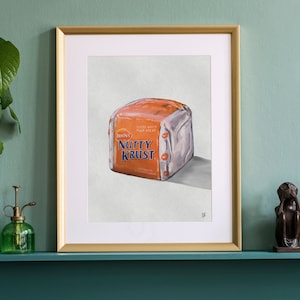 Può includere: Un'illustrazione incorniciata di una pagnotta di pane con il testo "Brown's Nutty Krust" sulla confezione. Il pane è avvolto in plastica e ha un colore arancio chiaro.