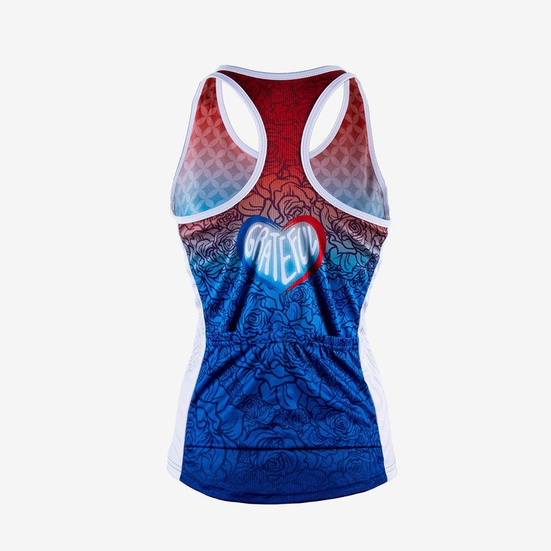 May include: White tank top with a blue, red, and white ombre design. The tank top has a heart-shaped graphic with the word "grateful" inside. The tank top has a floral pattern.
