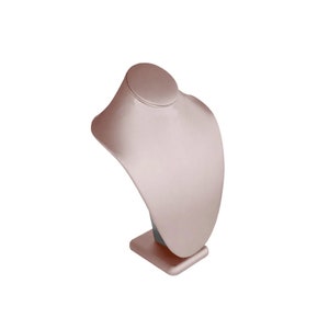 May include: A rose gold necklace display stand with a smooth, curved surface. The stand has a square base.