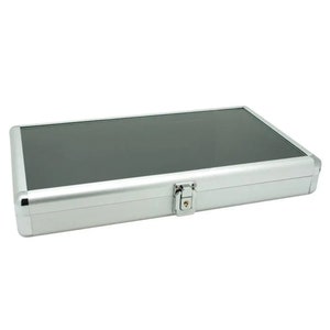 May include: A silver aluminum case with a black interior and a lock. The case is designed to hold and protect items.