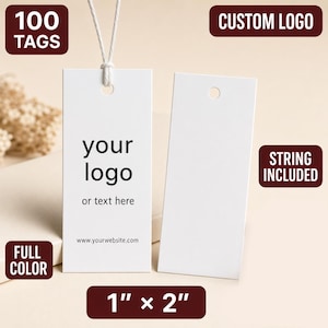 May include: Two rectangular white paper tags measuring 1 inch by 2 inches. One tag features black printed text reading your logo, or text here, and www.yourwebsite.com. A white string is attached to the top of one tag through a circular hole.