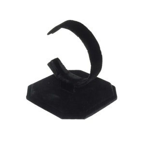 May include: Black velvet watch stand with a hexagonal base and a curved arm for holding a watch.