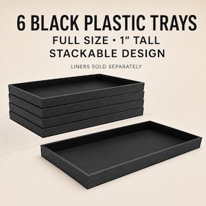 May include: Six black plastic trays with a stackable design. The text reads 6 BLACK PLASTIC TRAYS, FULL SIZE, 1" TALL, STACKABLE DESIGN, LINERS SOLD SEPARATELY. These rectangular trays feature a textured exterior and a smooth interior base.