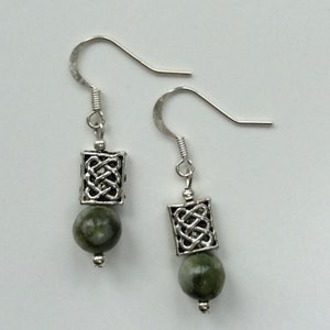 May include: Silver Celtic knot earrings with green stone beads.